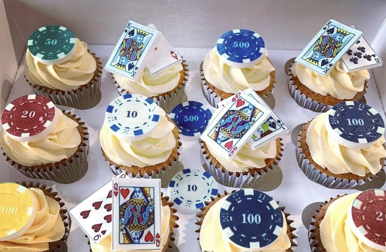 Yellow frosted cupcakes with edible cards and poker chips on top