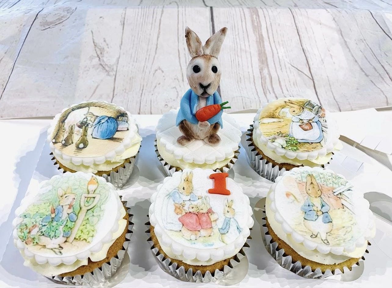 Peter Rabbit made out of fondant on top of book pictures for a first birthday