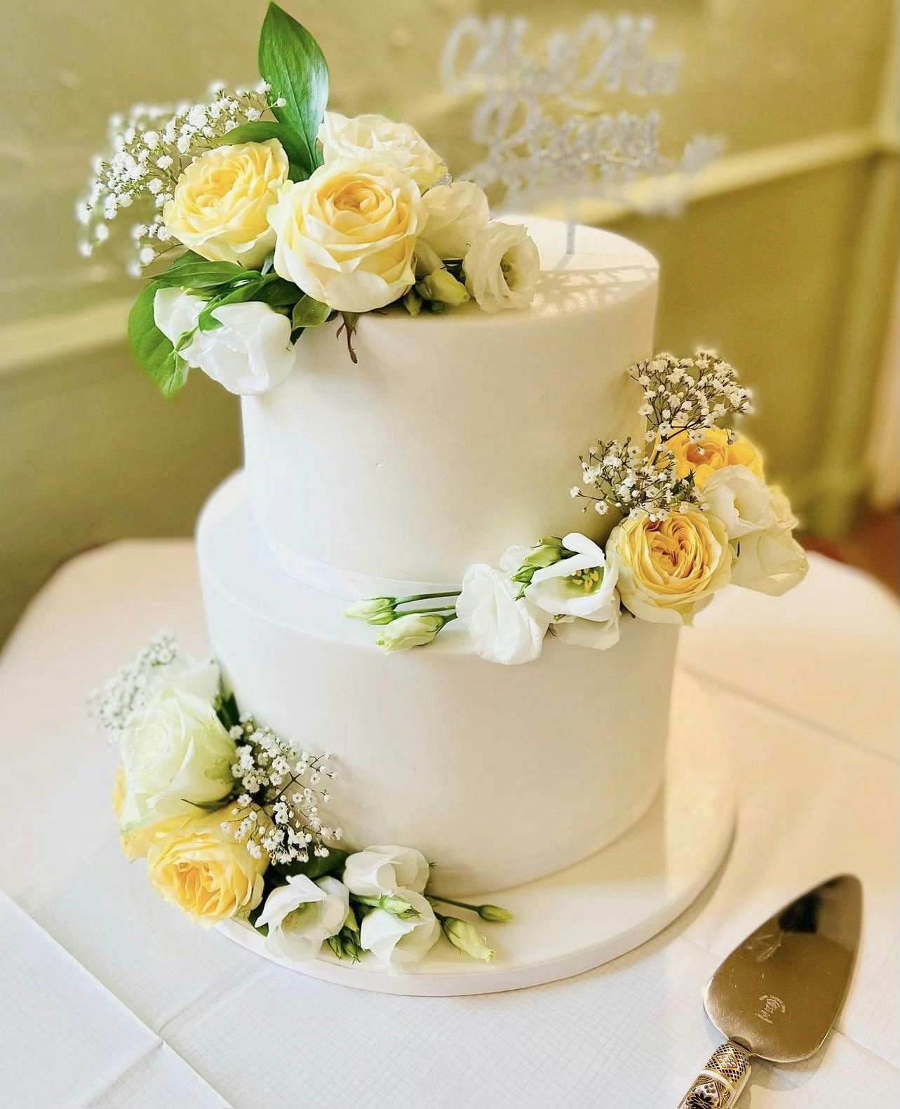 White wedding cake with yellow and white flowers